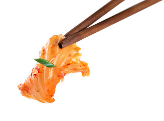 Chopsticks holding kimchi cabbage on white background. Hot fermented napa cabbage.