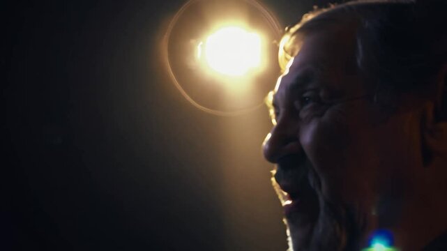 Zoom in on an elderly animated storyteller in a spotlight as they captivate an audience with expressive features