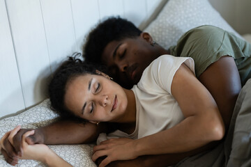 Obraz premium A happy couple cuddling in bed, laughing and enjoying a playful moment together in a cozy and relaxed atmosphere