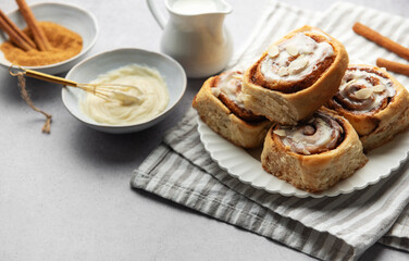 Freshly baked cinnamon rolls topped with icing and almond slivers
