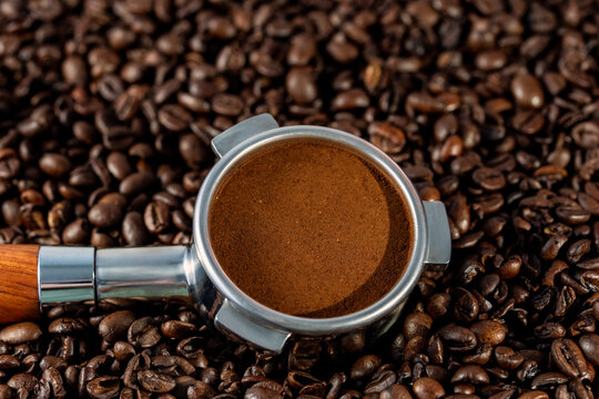 Portafilter with coffee grinds on coffee beans 