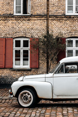 Old car parked in front of house wall