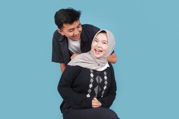 Portrait of Happy asian College man an women with jiba isolated on blue backround. Portrait of happy Asian muslim couple smiling, husband and wife hugging full of love, family concept