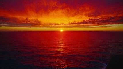 Obraz premium Fiery Sunset over Calm Ocean Water, Dramatic Vibrant Colors Reflecting on the Surface