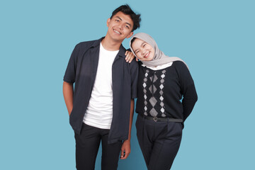 Portrait of Happy asian College man an women with jiba isolated on blue backround. Portrait of happy Asian muslim couple smiling, husband and wife hugging full of love, family concept