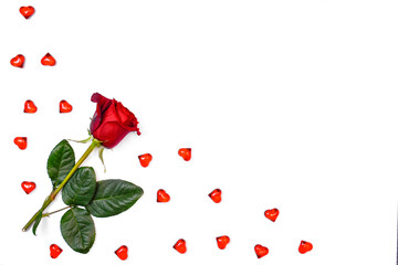 A red rose on a white background, located in the left corner next to small red decorative hearts.