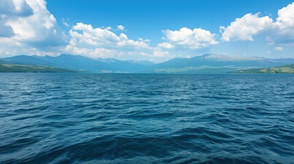 Obraz premium A large body of water with a few clouds in the sky