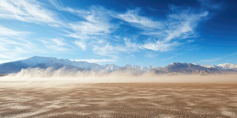 Fototapeta premium Wind blowing sand across a vast desert, with dunes in the background.