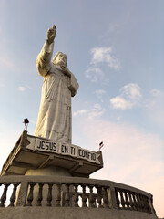 Naklejka premium Monument of Christ stands tall against colorful sky at sunset in serene location