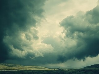 Dramatic storm clouds roll over a vast landscape with rolling hills and vegetation
