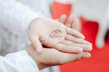 a pair of rings on the hands of the bride and groom, good for article and commercial