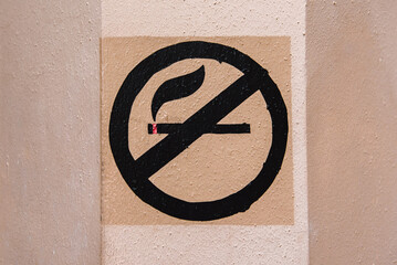 No Smoking sign painting on public wall in pastel tone.