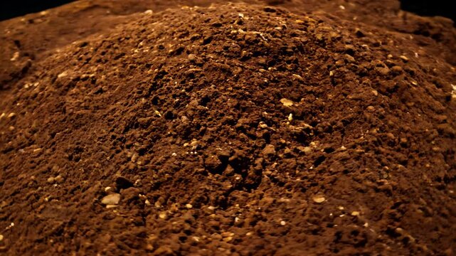 360-degree video of reddish-brown lateritic soil, revealing porous structure and iron oxide coating, ambient light shows uniform color and hardened nature