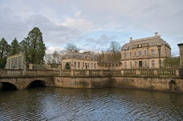 The imposing Huis De Voorst near Eefde with bridge over moat under a beautiful sky at the end of a winter day.