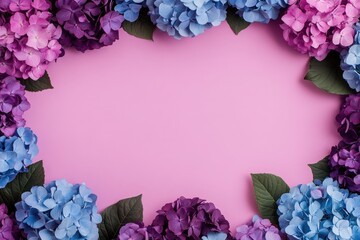 A vibrant arrangement of hydrangeas in shades of blue and purple, creating a beautiful frame on a pink background.
