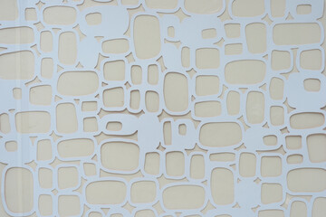 die-cut overlay sheet with rounded square cutouts on beige paper