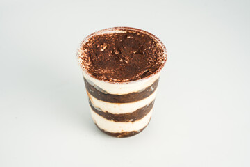 Tiramisu in a clear plastic cup showing the layers isolated on white background
