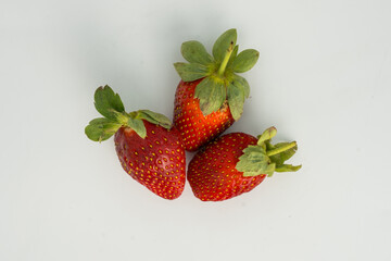 Fresh, ripe strawberry. Whole strawberry with leaf isolated on white background. Perfect retouched strawberry, not AI.