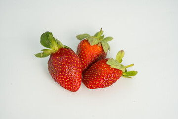 Fresh, ripe strawberry. Whole strawberry with leaf isolated on white background. Perfect retouched strawberry, not AI.