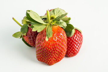 Fresh, ripe strawberry. Whole strawberry with leaf isolated on white background. Perfect retouched strawberry, not AI.