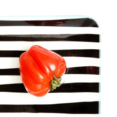 Small bright red deeply ribbed tomatoes isolated on white background