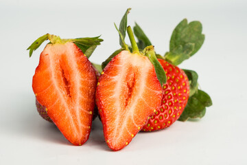 Fresh, ripe strawberry. Whole strawberry with leaf isolated on white background. Perfect retouched strawberry, not AI.