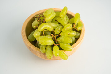 Grapes in a wooden plate on a white background isolated
