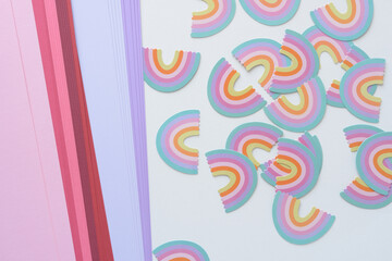 Obraz premium layered pink and lavender paper and die-cut rainbow confetti on blank paper