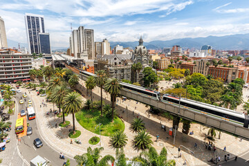 Medellin skyline with Metro de Medellín train at Plaza Botero in Medellin, Colombia