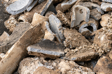 Close up of old broken cement pipes that were due for renewal, and other garbage, collected for recycling.
