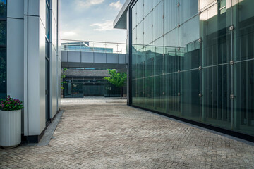 Modern Urban Pathway Between Glass Buildings Under Clear Sky
