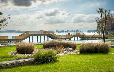 Scenic Lake View with Modern Walkway and Lush Greenery
