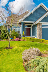 Entrance of grey painted luxury house in summer with stair steps and nice landscape in Vancouver,...
