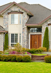 Entrance of grey painted luxury house in summer with stair steps and nice landscape in Vancouver, Canada, North America.