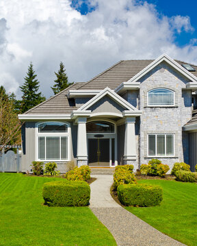 Entrance of grey painted luxury house in summer with stair steps and nice landscape in Vancouver, Canada, North America.