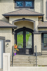 Fototapeta premium Entrance of grey painted luxury house in summer with stair steps and nice landscape in Vancouver, Canada, North America.