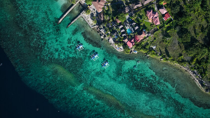 Aerial view of colorful waters and coastal homes in sunny Cebu Island, Philippines