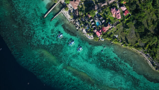 Aerial view of colorful waters and coastal homes in sunny Cebu Island, Philippines