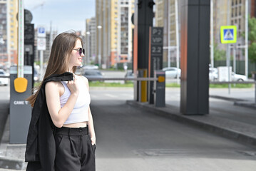 Woman walking near a retractable gate in front of a modern building.