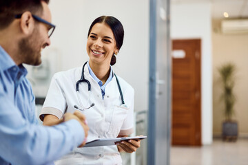 Medical Professional Smiling While Listening to a Patient in a Modern Clinic