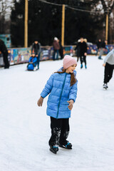 Beautiful happy girl, child teenager skating on ice on outdoor rink. Photography, portrait, hobby and sport concept.