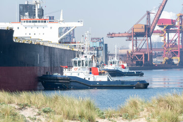 Bateau poussé par deux remorqueurs dans le port de Dunkerque