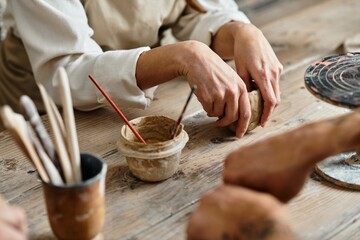A lovely couple enjoys shaping clay together in their pottery class.
