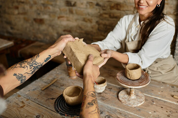 couple enjoys shaping clay together in a pottery class, sharing love and laughter.