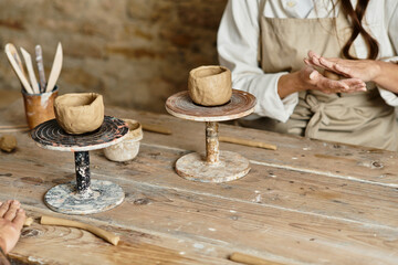 Couple shapes clay in a pottery class, enjoying quality time and creating memories.