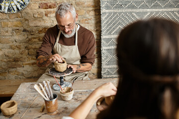 Beautiful couple hones their pottery skills, creating unique pieces while enjoying quality time.