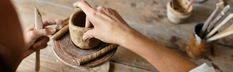 A mature woman spends quality time in a pottery class, shaping clay, banner