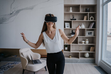 Excited woman experiences VR adventure in spacious, modern living room, embodying innovation and tech enjoyment.