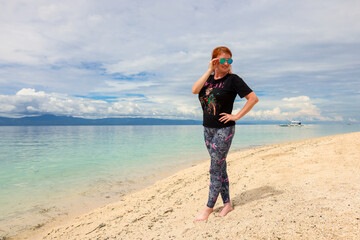 A tourist relaxes on the sunny beaches of the Philippines by the water