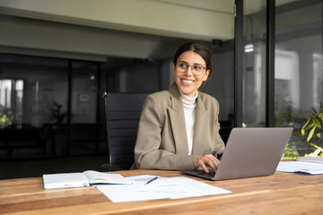 Smiling professional financial it specialist latin hispanic business lady working on laptop pc...